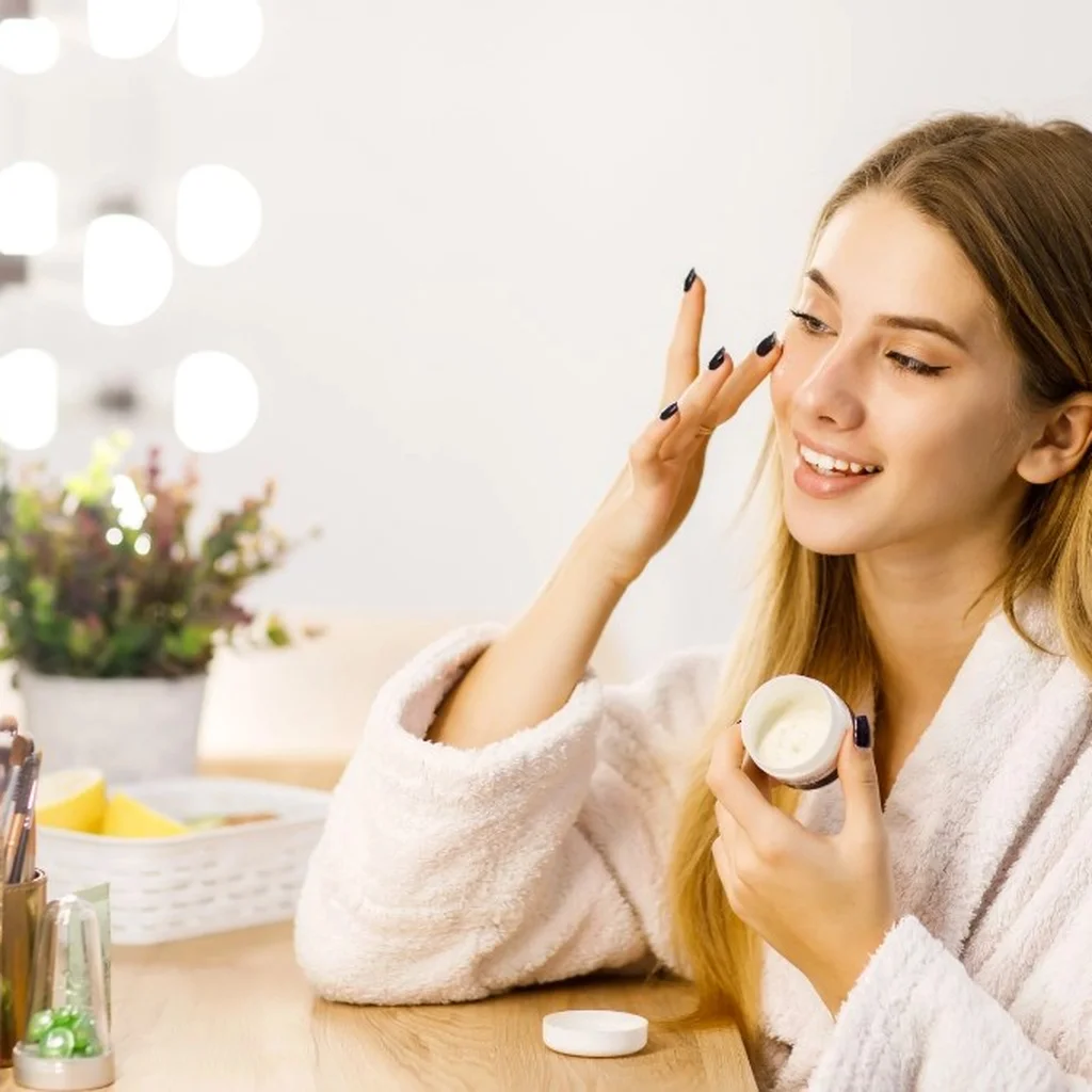 A creator applying skincare cream at a vanity